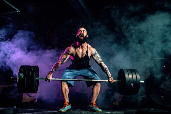 Muskulös fitness man gör deadlift en skivstång över huvudet i moderna fitnesscenter. Funktionell träning. — Stockfoto