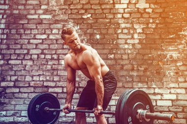 Atletik bir adam halterle çalışıyor. Kuvvet ve motivasyon
