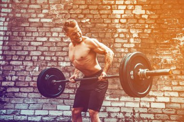 Atletik bir adam halterle çalışıyor. Kuvvet ve motivasyon