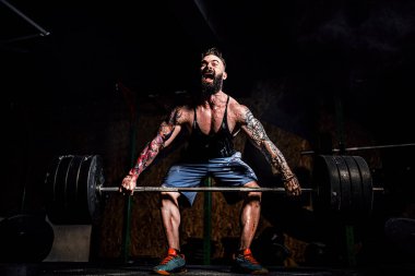 Modern Fitne 'de halter kaldıran kaslı fitness adamı.