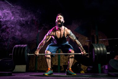 Modern Fitne 'de halter kaldıran kaslı fitness adamı.