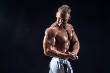 Stüdyoda poz veren yakışıklı güçlü vücut geliştirici.