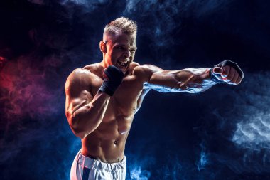 Boks eldivenli kaslı üstsüz dövüşçü.