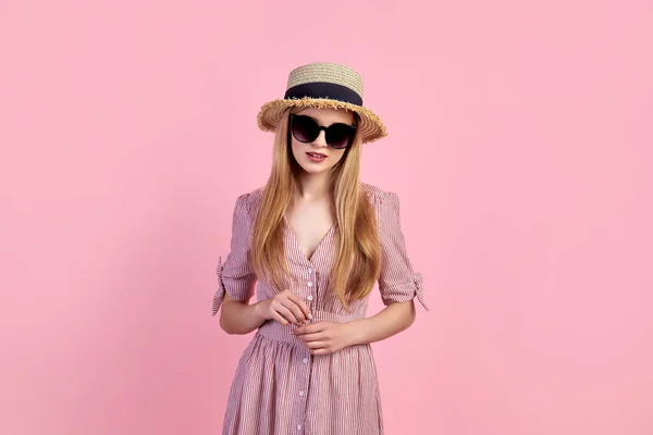 Menina loira jovem vestindo vestido, chapéu de palha, isolado sobre fundo rosa — Fotografia de Stock