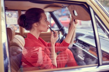 Eski arabadaki güzel genç kadın.