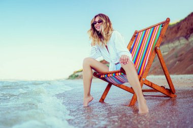 Güzel bir kadın plajda dinleniyor. Yaz tatili danışmanlığı