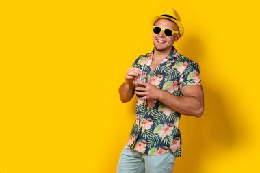 Parlak elbiseli bir adam, sarılı bir içecek.