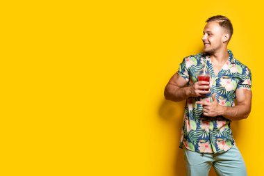 Parlak elbiseli bir adam, sarılı bir içecek.