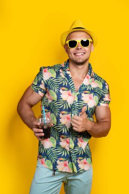 Parlak elbiseli bir adam, sarılı bir içecek.