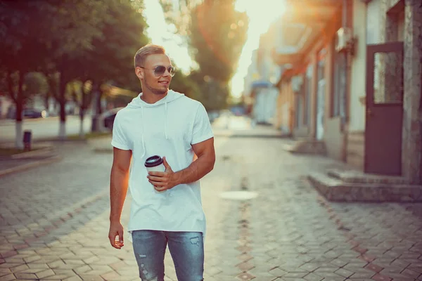 Alışveriş merkezinin yakınında bir fincan kahve ve akıllı telefonlu yakışıklı bir adam. Arkadaşımı bekliyorum.