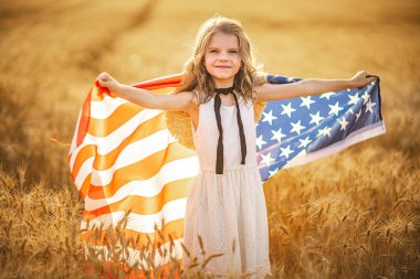 Beyaz elbiseli sevimli vatansever kız Amerikan bayrağı takıyor.