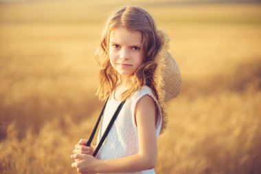 Gün batımı buğday tarlasında yürüyen küçük kız