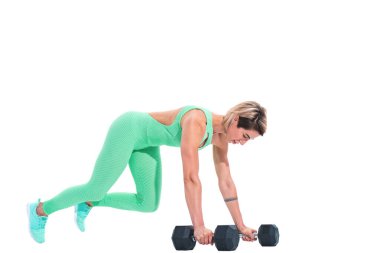 Beyaz arka plan üzerinde izole halterler üzerinde kalas egzersizi yapan kadın.