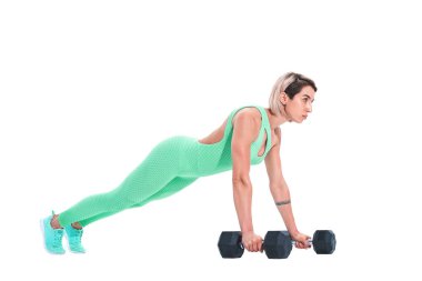 Beyaz arka plan üzerinde izole halterler üzerinde kalas egzersizi yapan kadın.