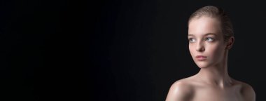 Mükemmel yüzlü ve siyah arka planda temiz tenli şık bir kadın.