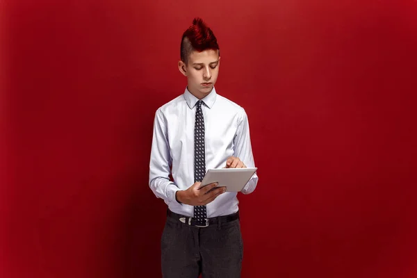 Elegante punk con tablet sobre fondo rojo —  Fotos de Stock