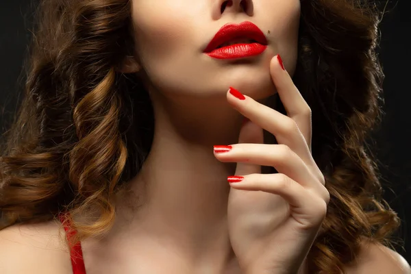Bella ragazza che mostra unghie manicure rosse. trucco e cosmetici. Bruna ragazza con i capelli lunghi e lucenti ricci — Foto Stock