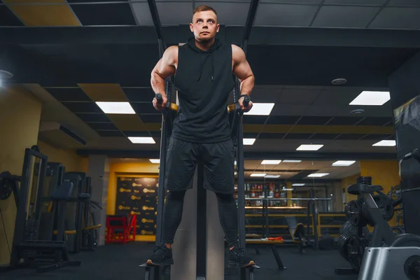 Hombre musculoso fuerte haciendo flexiones en barras irregulares en el gimnasio. Concepto de estilo de vida de entrenamiento. —  Fotos de Stock