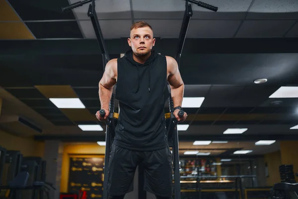Hombre musculoso fuerte haciendo flexiones en barras irregulares en el gimnasio. Concepto de estilo de vida de entrenamiento. —  Fotos de Stock