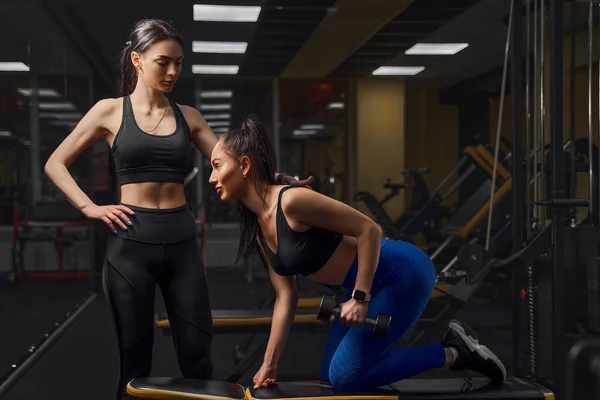 Mooie atleet vrouw oefenen met dumbells in fitness club. — Stockfoto