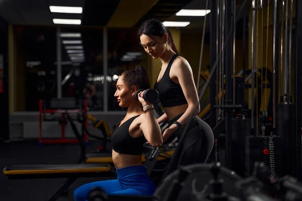 Mooie atleet vrouw oefenen met dumbells in fitness club. — Stockfoto