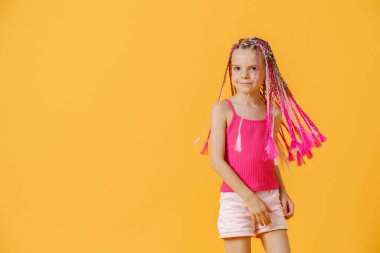 Pembe rastalı şık bir kız ve sarı bir sırtında poz veriyor.