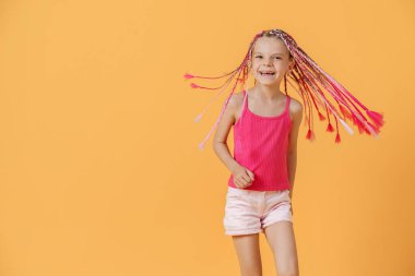 Pembe rastalı şık bir kız ve sarı bir sırtında poz veriyor.