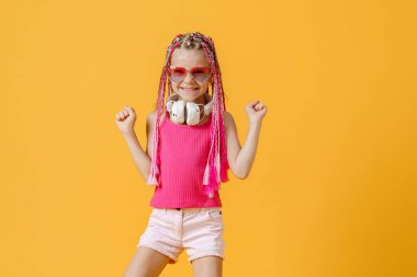 Parlak elbiseli, kulaklıklı ve parlak saçlı moda DJ kız.