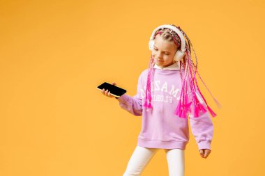 Güzel, modern bir kız pembe kulaklıklı, gülümseyen bir kız.