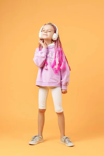 Niño adorable en gafas redondeadas con rastas rosadas escuchar — Foto de Stock