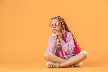 Yuvarlak gözlüklü, pembe saçlı şık bir kız.