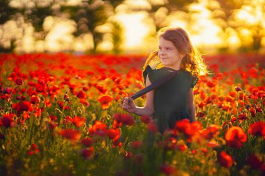 Haşhaş tarlasında güzel bir kız güzelliğin ve aromaların tadını çıkarıyor..