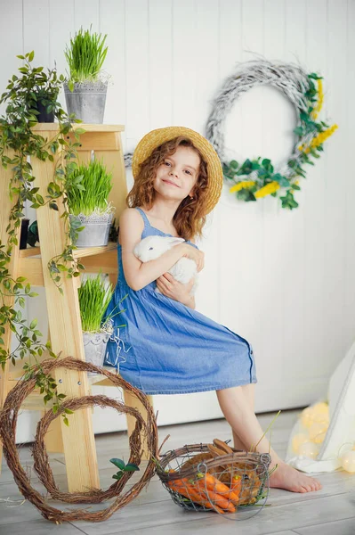 Feliz rindo menina brincando com um bebê coelho, abraçando h — Fotografia de Stock