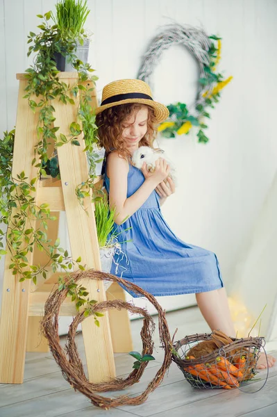 Feliz rindo menina brincando com um bebê coelho, abraçando h — Fotografia de Stock