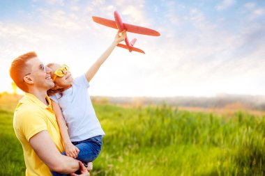 Mutlu baba ve kız uçakla oynuyor.