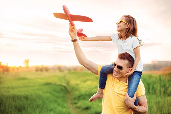 Счастливые отец и дочь играют с самолетом — стоковое фото