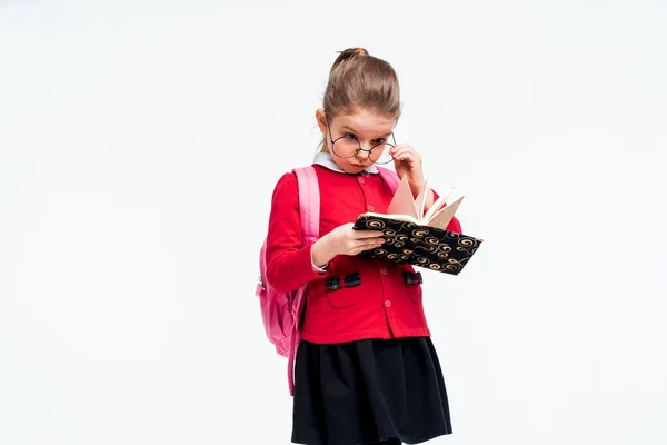 Menina adorável na jaqueta vermelha da escola, vestido preto, mochila — Fotografia de Stock