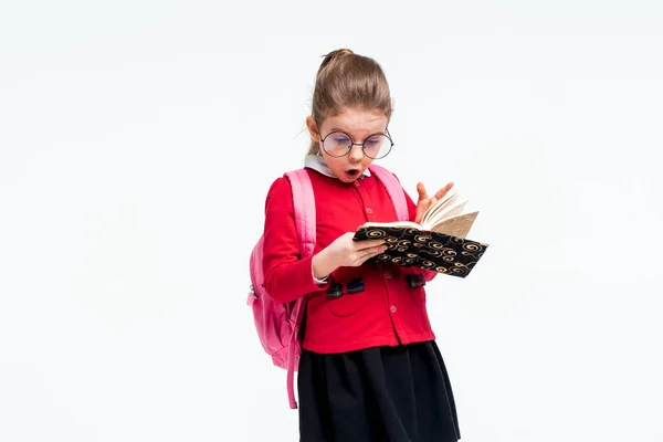 Schattig klein meisje in rode schooljas, zwarte jurk, rugzak — Stockfoto