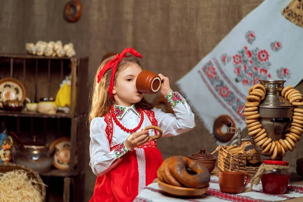 Söt flicka dricker te från samovar — Stockfoto