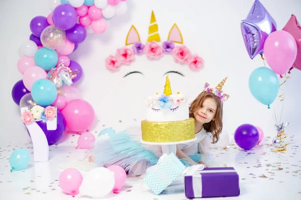 Menina unicórnio posando perto de bolo de aniversário feliz. Idéia para decorar — Fotografia de Stock