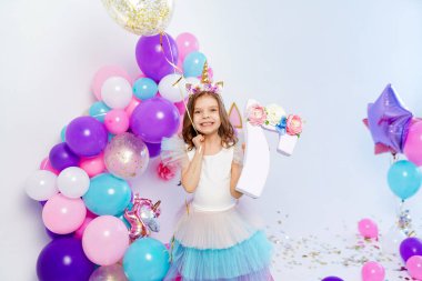 Altın konfeti taşıyan tek boynuzlu at kız balonu ve harf 7. Fikir.