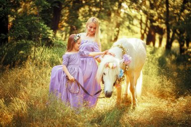 Benzer lavanta elbiseli anne ve kızı bir Un 'u okşuyor.