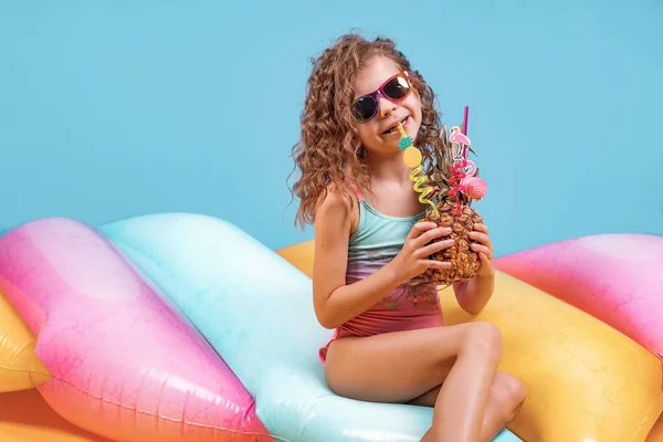 Beautiful girl in colorful swimsuit and sunglasses holding pinea — Stock Photo, Image