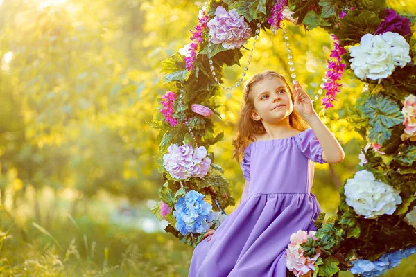 Schattig klein meisje dragen lila jurk poseren terwijl zitten in rin — Stockfoto