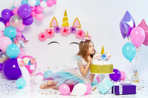 Unikornis lány pózol közel boldog szülinapi torta. A dekatinra vonatkozó ötlet — Stock Fotó