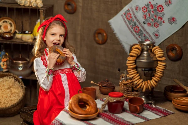 Adorabile ragazza seduta a tavola piena di cibo e samovar grande. Tra — Foto Stock