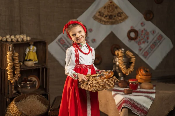 Όμορφο κορίτσι που κρατά καλάθι με κουλούρια και άλλα ψήσιμο στο παραδοσιακό — Φωτογραφία Αρχείου