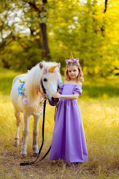 穿着紫色衣服，头戴独角兽花环，抱着头发的女孩 — 图库照片
