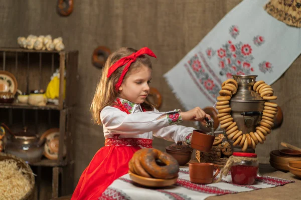 Adorável menina derramando chá de samovar — Fotografia de Stock