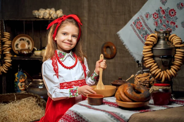 Menina adorável sentada à mesa cheia de comida e grande samovar. Tra — Fotografia de Stock